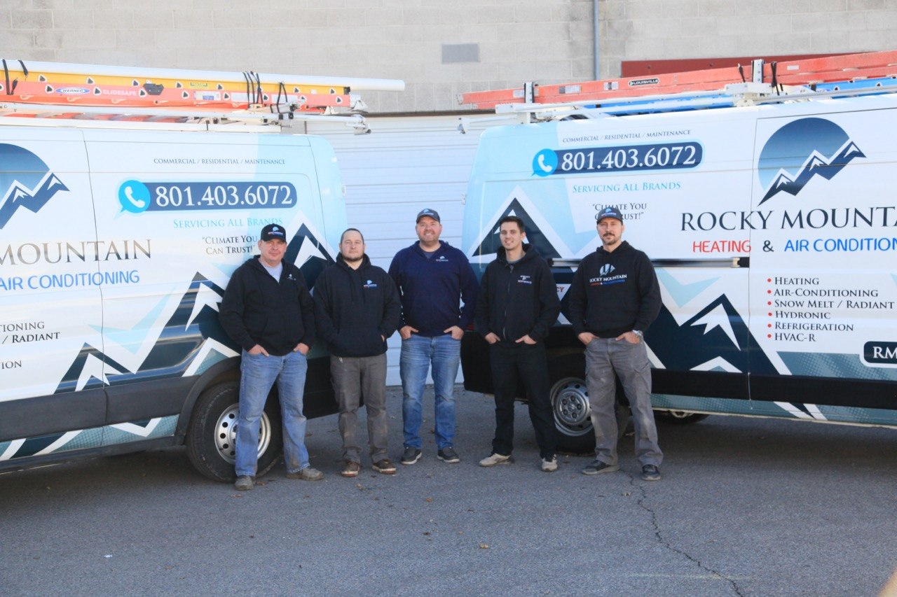 Rocky Mountain Heating and Air Conditioning team standing in front of service vans